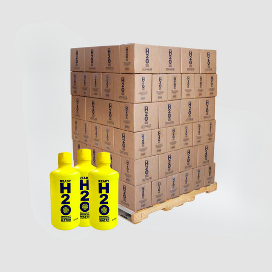 A pallet of brown boxes labeled American Reserves sits next to three yellow bottles marked Bulk 20 Year Long Term Emergency Drinking Water - 1 Liter Bottles, on a white background, promising bacteria-free emergency drinking water.