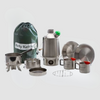 Explore the Kelly Kettle® Ultimate Scout Kit by American Reserves, including a Stainless Steel Camp Kettle, mugs, plates, a cooking pot, and a green carrying bag—all showcased on a crisp white background.